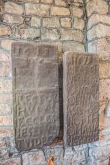17th-century gravestones against the church wall