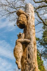 An amusing sculpture of a bear climbing a honey tree