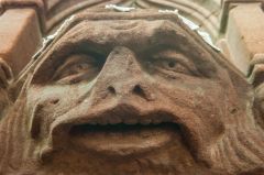 Grotesque carved head on the piscina underside