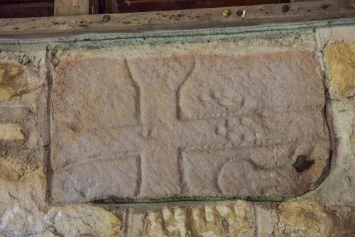 Medieval cross fragment set in the porch wall