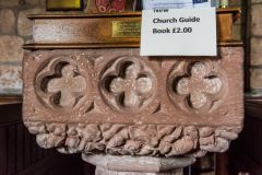 The richly carved medieval font
