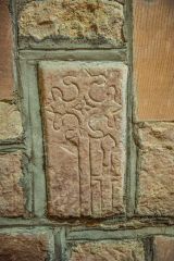 A floriated grave slab set into the wall