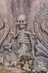 Carved figure of a skelton an an 18th-century grave