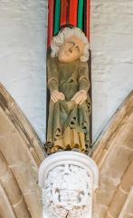 Painted corbel above a Green Man carving
