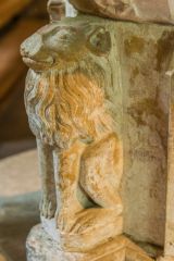 A carved lion on the font stem