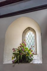 A narrow lancet window in the south wall