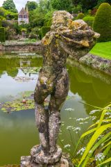 A statue stands beside a fishpond
