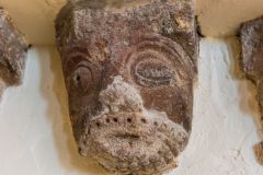 A 12th-century corbel head, reddened by fire