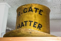 A gilded hat maker's shop sign