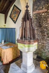 The plain octagonal font and wooden cover