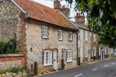 A row of traditional brick and stone cottages on Burnham Road
