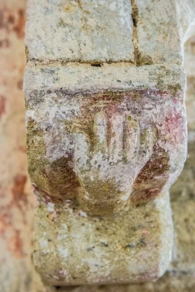 A carved hand supporting an arch