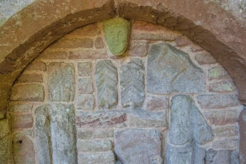 Blocked Norman north door with Roman tiles and Romanesque carving