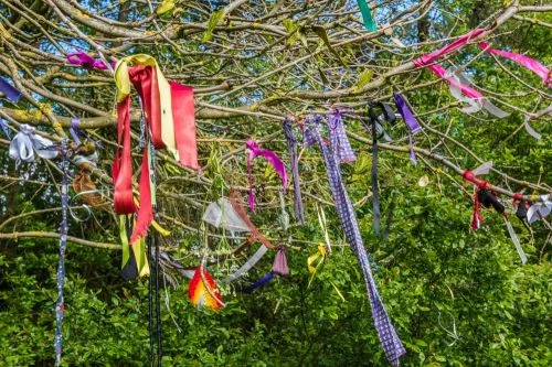 Offerings of colourful cloth hang from a nearby tree