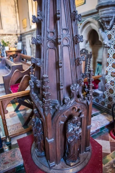 The richly carved medieval font cover