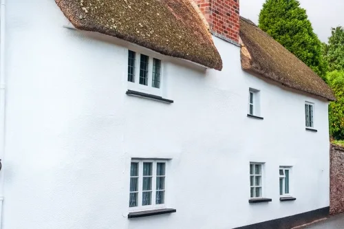 A whitewashed thatched and cob cottage