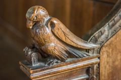 Bench end of a bird with a holy book