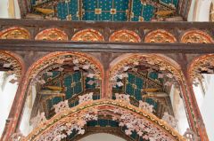 The richly carved top of the screen