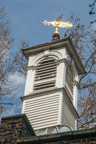 The elegant bell tower and gilded weathervane
