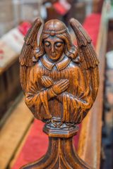 Winged angel pew end carving