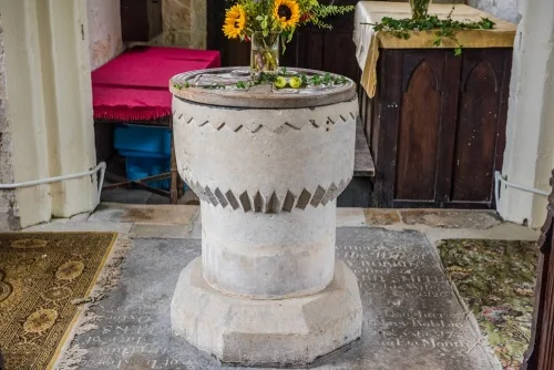 The plainly carved 12th-century font