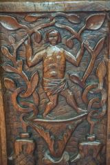 16th-century carved bench end of a man in a loin cloth