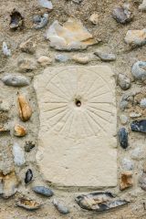 A medieval scratch dial outside the church