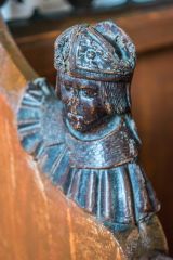 A medieval bench end depicting a bishop