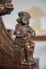 Bench end of a musician playing a lute