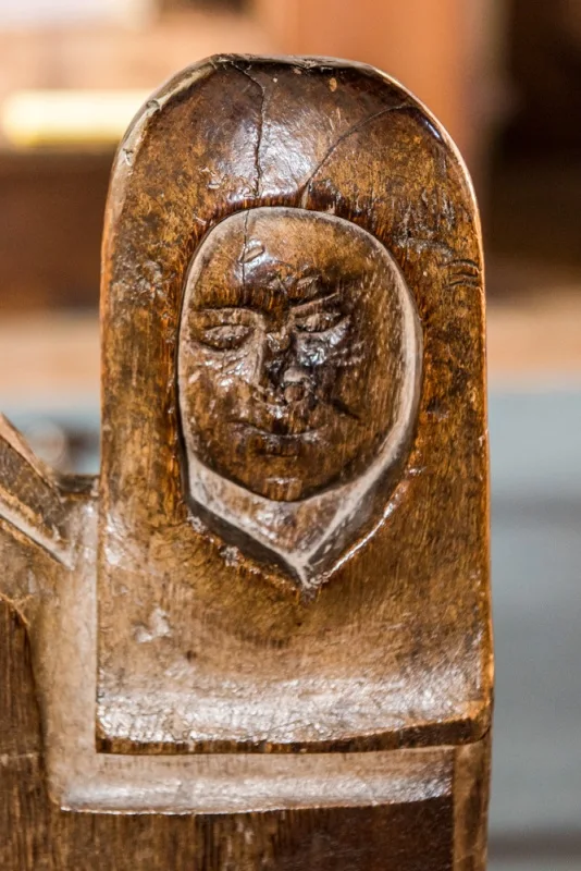 15th century bench end carving of a woman