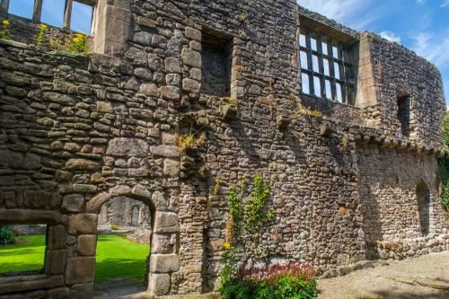 A medieval wall with later mullioned windows