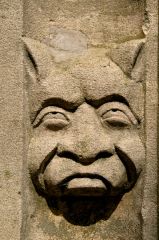 Grotesque carved head on the south porch arch