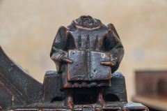 A headless carved bench end figure