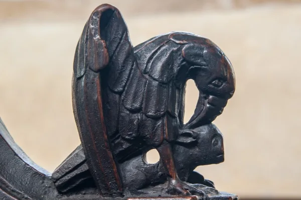 15th century bench end of a bird attacking a lamb