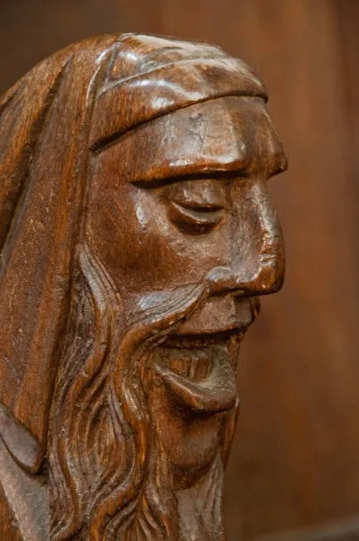 Carved head bench end on a choir stall