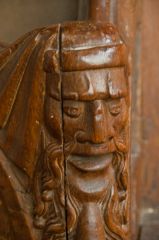 A bearded figure arm rest