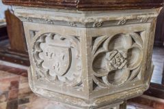 Carved faces of the font bowl