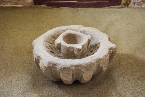 The 13th-century font and holy water stoup