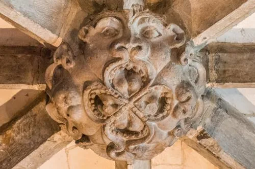 Grotesque grinning face on a roof boss