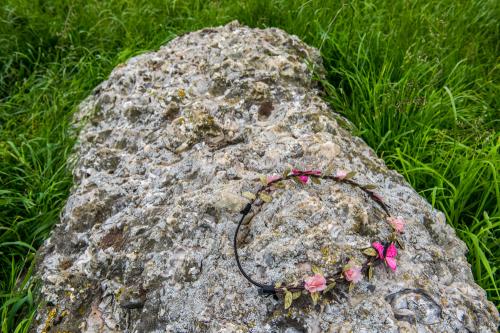 Garland of flowers on a fallen stone