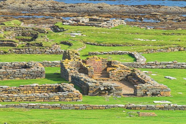 Looking down onto the settlement from the hill above. Here the walls of the church are the most visible, with the walls of the earliest Norse buildings beyond and to the left. Photo of the Brough of Birsay, Orkney Islands.