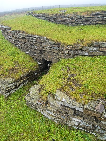Here you can see the layered 'wedding cake' style of the cairn. Entry is not through the opening in the photo, but through a hatch on the roof. Photo of the Orkney Islands, Scotland.