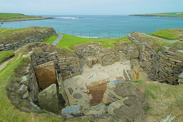 Looking out to the Bay of Skaill. Coastline erosion has brought the sea much closer to the village. Photo of Skara Brae, a prehistoric village on the Orkney Islands, Scotland.
