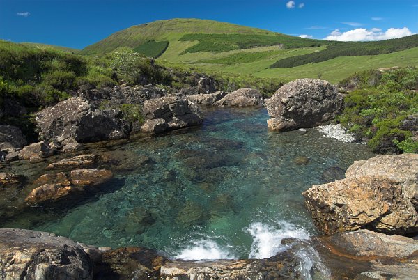 A pool of crystal clear water in a superb scenic setting beneath the peaks of the Cuillin Hills. Stock photo of the Fairy Pools in Glen Brittle, Isle of Skye, Scotland. Part of the Britain Express Travel and Heritage Picture Library, Scotland collection.