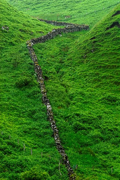 A stone wall zigs up a hillside near Portree. Stock photo of Portree on the Isle of Skye, Scotland. Part of the Britain Express Travel and Heritage Picture Library, Scotland collection.