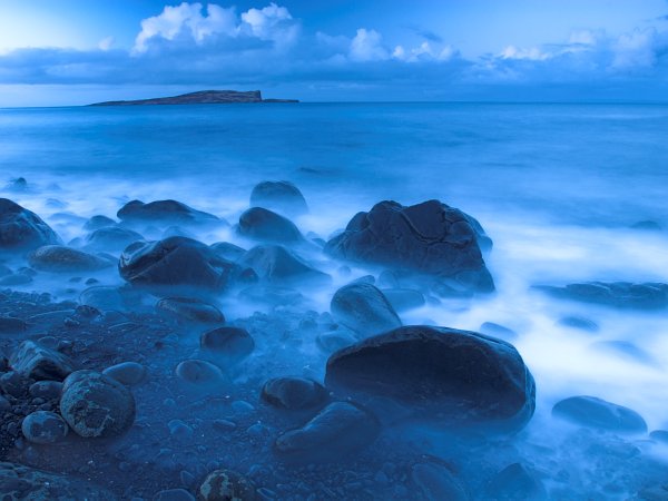 An eerie mist cloaks rocks on the shore at Staffin. Stock photo of the coast at Staffin on the Isle of Skye, Scotland. Part of the Britain Express Travel and Heritage Picture Library, Scotland collection.